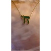 Collier or avec pendentif vert sur fond nacré.