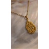 Collier pendentif arabe doré sur fond marbré.