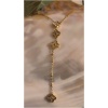 Collier en or avec motifs floraux sur fond beige.