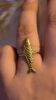 Bague poisson dorée sur doigt.
