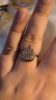 Main portant une bague flamme argentée.
