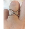 Bague croisée en strass sur doigt.