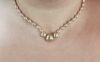 Collier en perles dorées autour d'un cou.