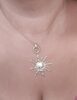 Collier pendentif doré en forme de soleil.