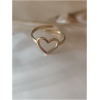 Bague dorée en forme de cœur sur fond nacré.