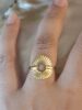 Bague dorée sur un doigt.