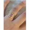 Main avec bague dorée et pierre rose.