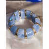 Bracelet bleu et doré sur table.