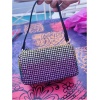 Sac brillant posé sur une table colorée.